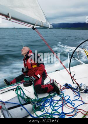 Man adjusting rigging on sailboat in Iceland Stock Photo