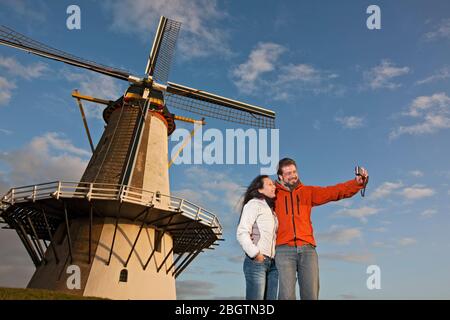 Mature couple taking selfie with windmill in the Netherlands Stock Photo