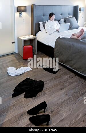 Businesswoman working on her laptop in hotel room Stock Photo