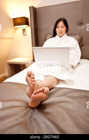 Businesswoman using laptop in hotel room Stock Photo