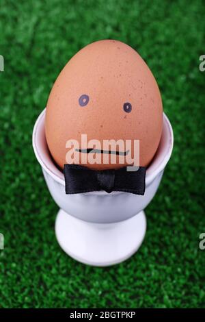 Edd in egg cup on green background Stock Photo