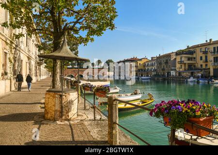 View of the Canale di Mezzo canal in the old town (Unesco W. H. Site) with the Ponte dei Voltoni bridge (16th c.), Peschiera del Garda, Verona, Italy Stock Photo