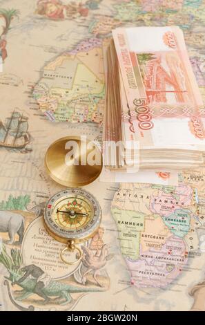 Compass with a bundle of big money are on the map Stock Photo