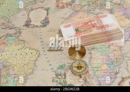 Compass with a bundle of big money are on the map Stock Photo