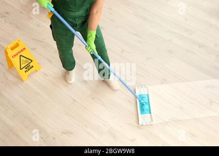 Male janitor mopping floor in room Stock Photo