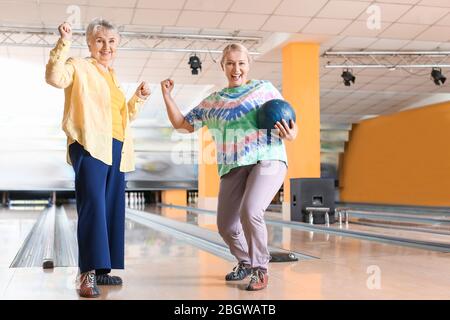 Senior women playing bowling in club Stock Photo