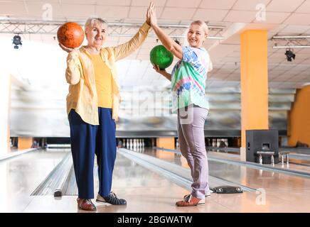 Senior women playing bowling in club Stock Photo