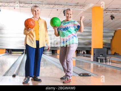 Senior women playing bowling in club Stock Photo