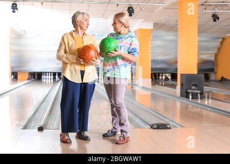 Senior women playing bowling in club Stock Photo