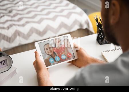 Young man video chatting with his family at home Stock Photo