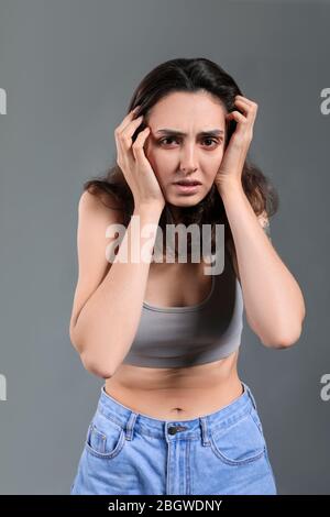 Young woman with anorexia on grey background Stock Photo