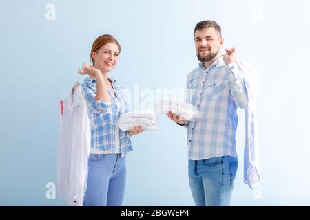 Workers of modern dry-cleaner's on color background Stock Photo