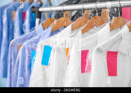 Rack of clean clothes hanging on hangers at dry-cleaning Stock Photo - Alamy