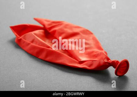 Popped red balloon on paper background Stock Photo