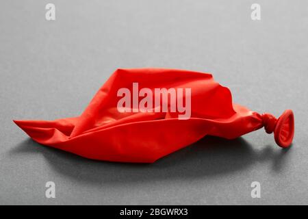 Popped red balloon on paper background Stock Photo