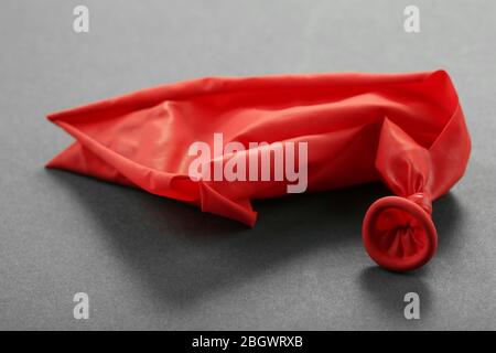 Popped red balloon on paper background Stock Photo