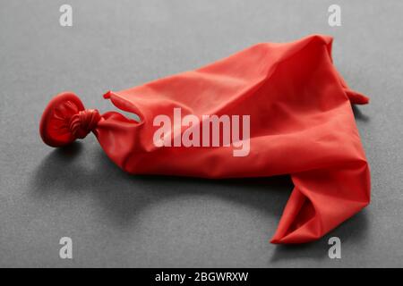 Popped red balloon on paper background Stock Photo