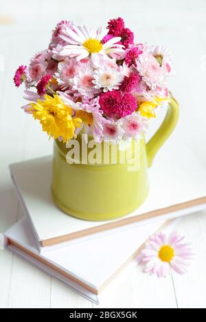 Beautiful flowers in pitcher on table close-up Stock Photo