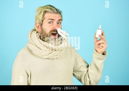 free your stuffy nose. no addiction to medicals. coronavirus from china. happy hipster presenting best remedy. Nasal drops plastic bottle. pandemic concept. man treat runny nose with nasal spray. Stock Photo
