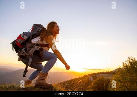 Portrait of happy young woman hiking in the mountains Stock Photo