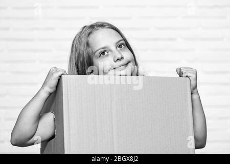 Make moving easier. Girl small child carry cardboard box. Move out concept. Delivering your purchase. Kid moving out. Moving routine. Packaging things. Prepare for moving. Rent house. Real estate. Stock Photo