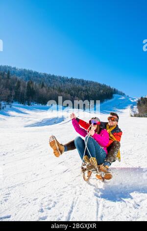 Young Happy Couple On Sledge Having Fun Stock Photo