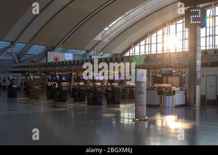 Sun shining into￼ a vacant￼ Air Canada check-in area inside Terminal 1 at Toronto Pearson Intl. Airport during the COVID-19 pandemic. Stock Photo