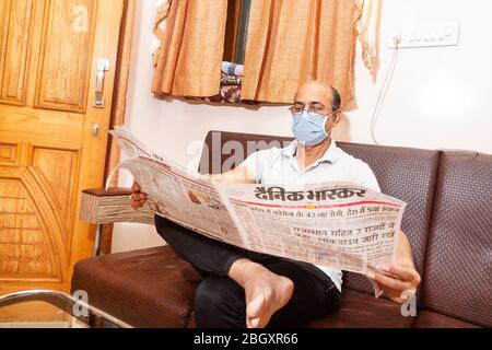 Jodhpur, Rajashtbn, India. 30 March 2020. Man wearing mask reading newspaper, man quarantine, isolated, stay home stay safe, Coronavirus, COVID-19 out Stock Photo