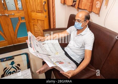 Jodhpur, Rajashtbn, India. 30 March 2020. Man wearing mask reading newspaper, man quarantine, isolated, stay home stay safe, Coronavirus, COVID-19 out Stock Photo