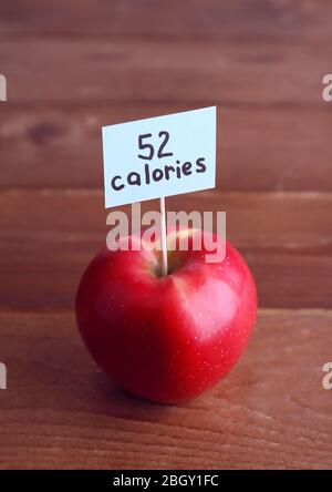 Red apple with calories count label on wooden table background Stock Photo