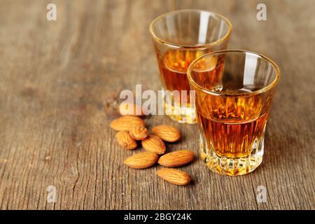 Dessert liqueur Amaretto with almond nuts, on wooden table Stock Photo