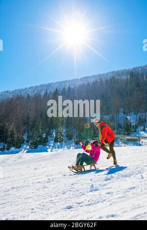 Young Happy Couple On Sledge Having Fun Stock Photo