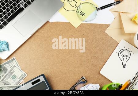 Symbol of idea as light bulb in notebook with crumpled paper on wooden desk background Stock Photo