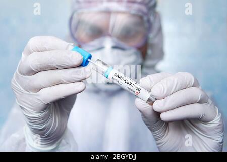 Negative test result for SARS-CoV-2, coronavirus causing CONVID-19 disease. mucosal smear. Sputum examination. a scientist in a protective suit. Stock Photo