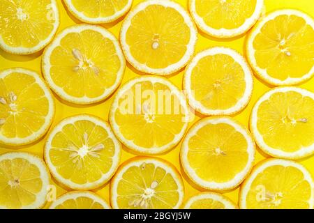 Lemon cut in half background. A slices of fresh yellow lemon pattern. Lemon pieces in different sizes. Stock Photo