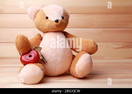 Teddy Bear with padlock in shape of heart on wooden background Stock Photo
