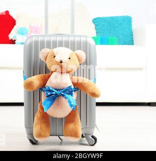 Suitcase with teddy bear in room on white sofa background Stock Photo