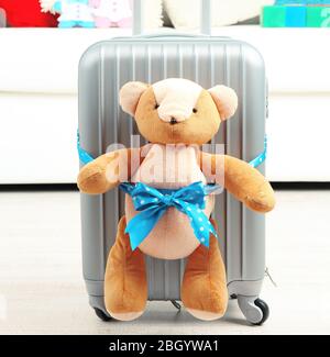 Suitcase with teddy bear in room on white sofa background Stock Photo