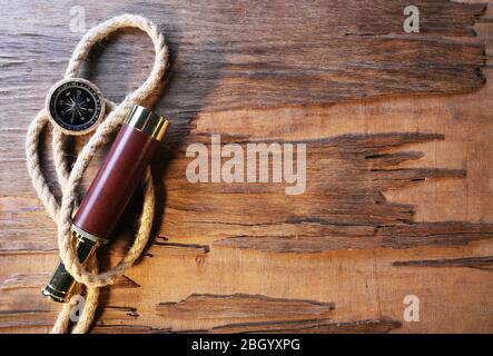 Marine still life spyglass, compass and rope on wooden background Stock Photo