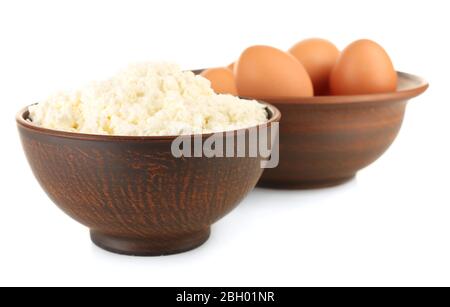 Cottage cheese and eggs in clay bowls isolated on white Stock Photo