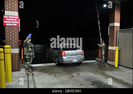 Master Sgt. Ariel McVicker, a security forces squadron augmentee and Staff Sgt. Xavier Graciani, a security forces specialist, both assigned to the Ohio National Guard’s 180th Fighter Wing, wears protective gloves while motioning vehicles, arriving at the installation, through the main gate, March 17, 2020. The 180FW implemented local Force Health Protection measures in an effort to safeguard military and civilian personnel and to help prevent wide-spread of COVID-19 in Northwest, Ohio. Air National Guard photo by Senior Master Sgt. Beth Holliker. Stock Photo