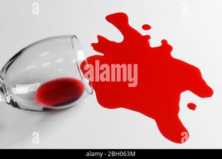 Red wine spilled from glass on white background Stock Photo