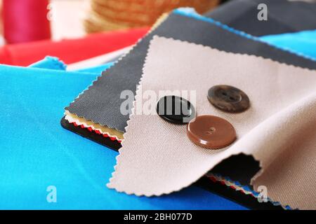 Colorful fabric samples with buttons and threads on wooden table background Stock Photo