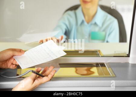 Teller window with working cashier Stock Photo