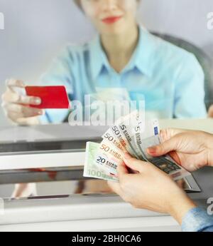 Teller window with working cashier Stock Photo