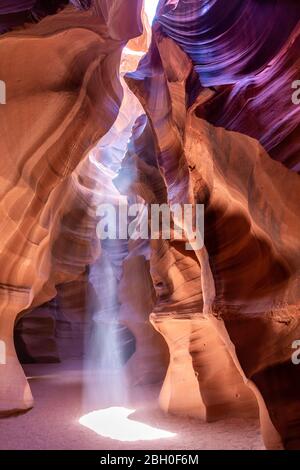 In the Antelope Canyon, a ray of sun light shines from an opening in the vault Stock Photo