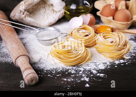 Raw homemade pasta and ingredients for pasta on wooden background Stock Photo