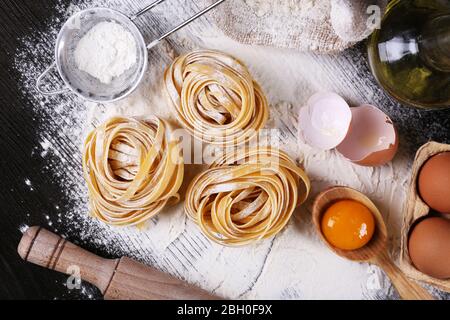 Raw homemade pasta and ingredients for pasta on wooden background Stock Photo