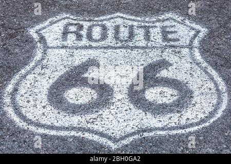 Symmetrical close up of a white Route 66 badge painted on the asphalt