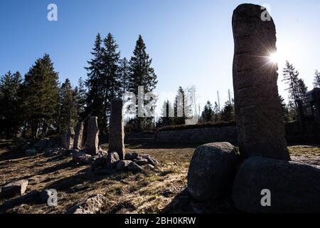 23 April 2020, Lower Saxony, Oderbrück: Granite stelae stand in the backlight of the sun at the floodplain at the Oderteich in the Harz Mountains. Photo: Swen Pförtner/dpa Stock Photo